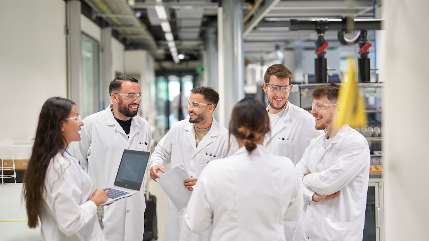 scientists in white lab coats laughing together