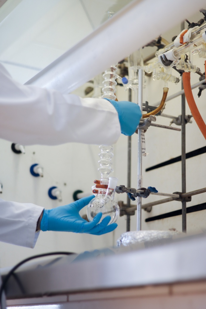 Scientist hands with gloves in chemistry lab performing green chemistry practices